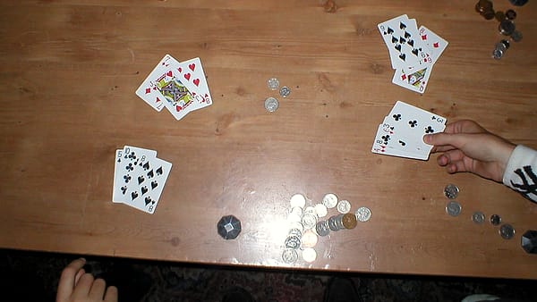 Several plain plastic gift cards fanned out on a wooden table beside a torn paper envelope