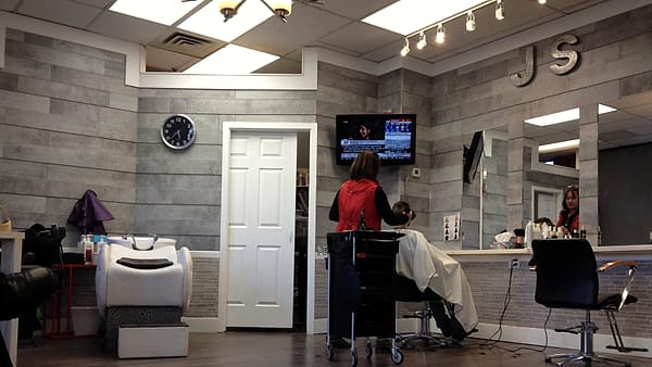 A stylist's workstation with combs, clippers and brushes laid out in a row on a folded towel beside a mirror