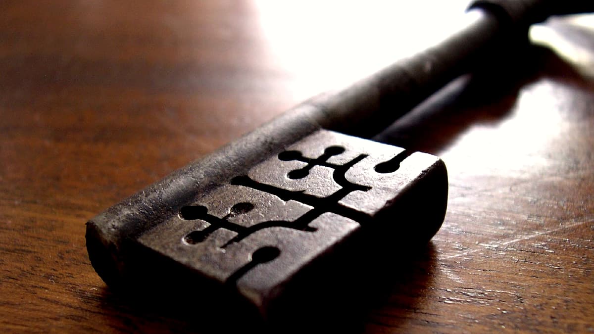 A pen resting on the signature line of a printed agreement, with a small set of car keys placed alongside